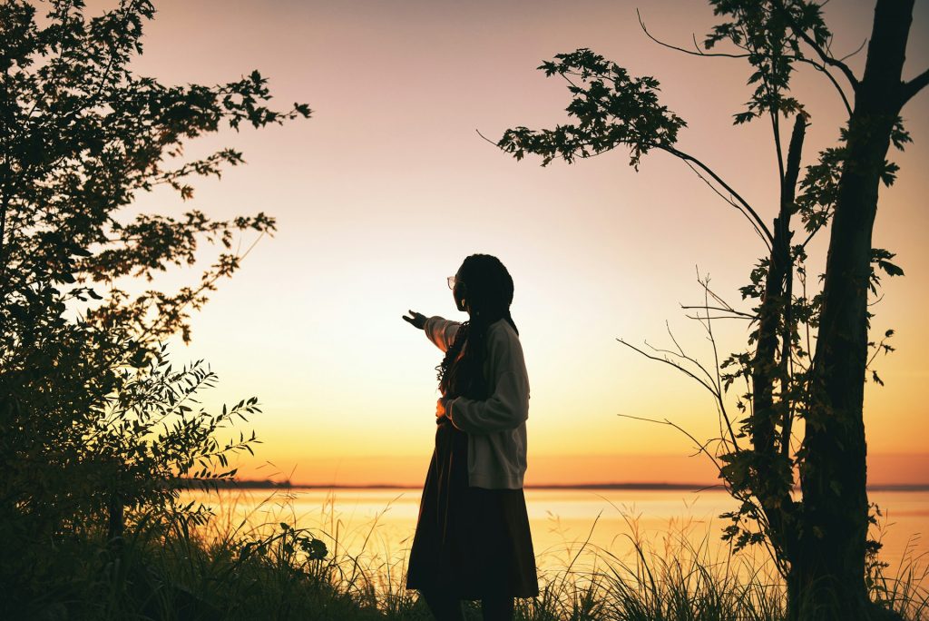 Woman journaling outdoors at sunset, symbolizing hope and vitality