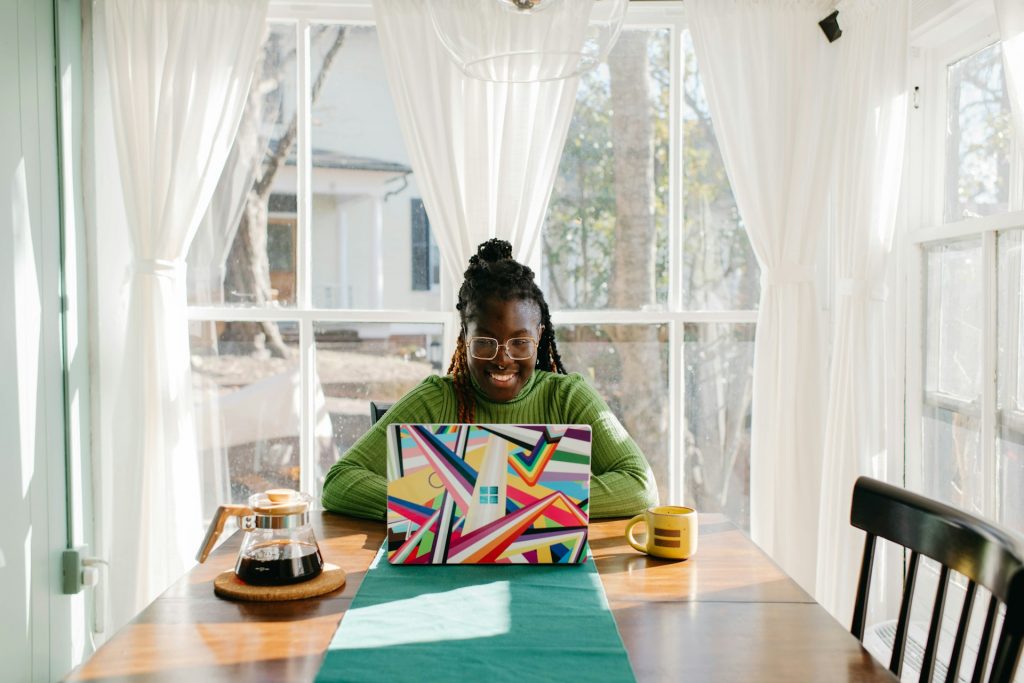 Woman of color journaling indoors, symbolizing empowerment and self-reflection
